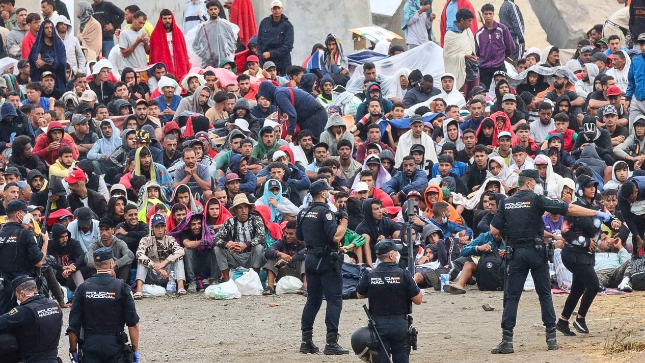 Migrantes vuelven a ocupar la playa del Trampolín tras ser desalojados mientras la Policía escolta a los servicios de limpieza
